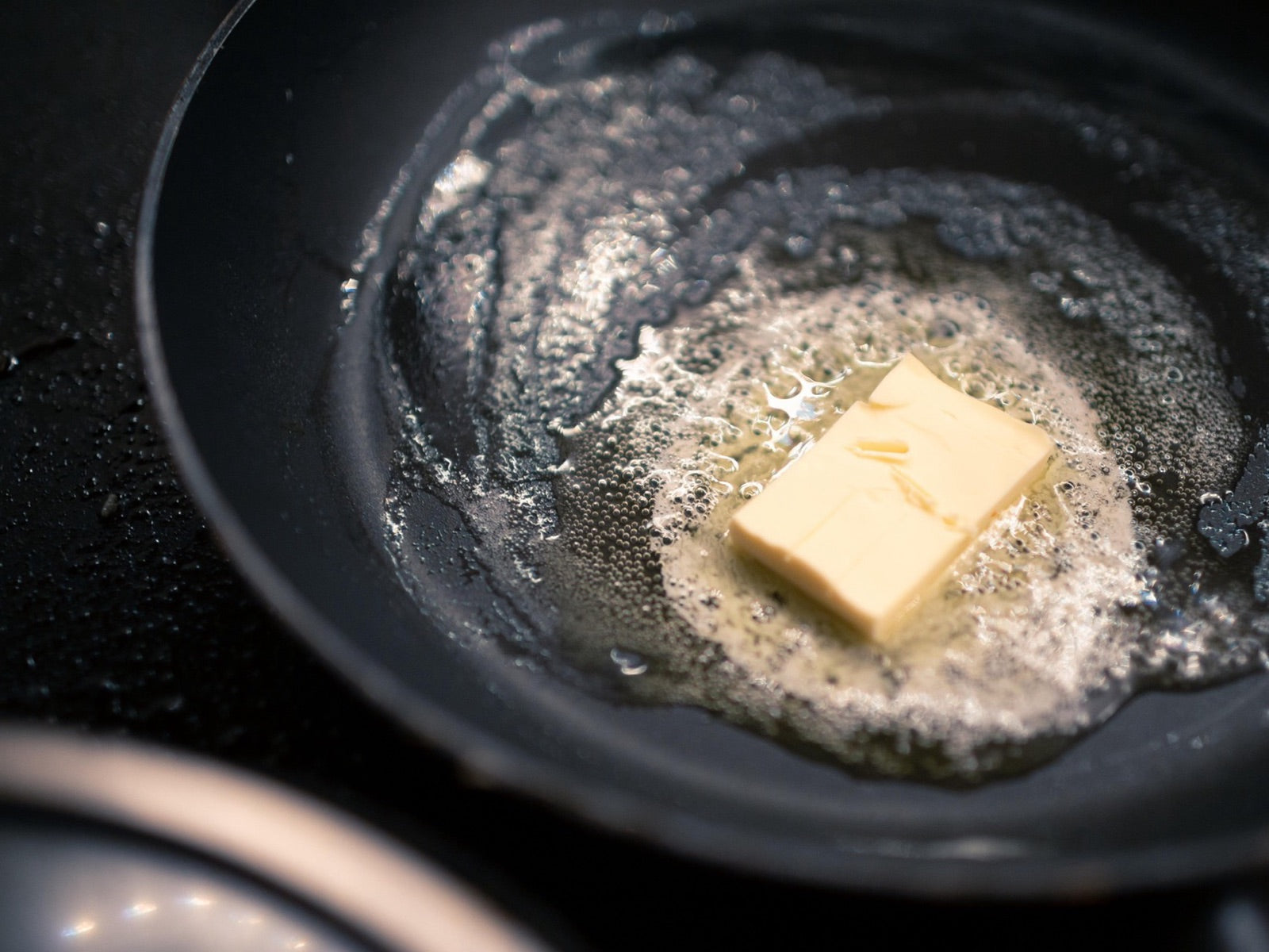 Close-up of butter melting in a nonstick frying pan on the stove